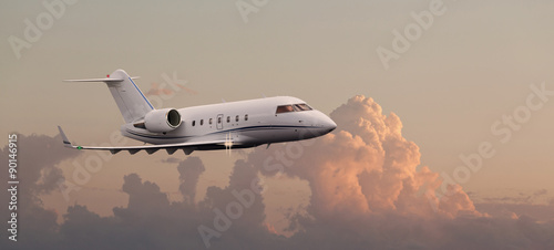 Private jet in the air with clouds in the background