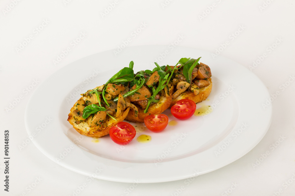 Bruschetta with mushrooms and cherry tomatoes basil on a plate isolated for the menu Bruschetta with mushrooms and cherry tomatoes basil on a plate isolated for the menu