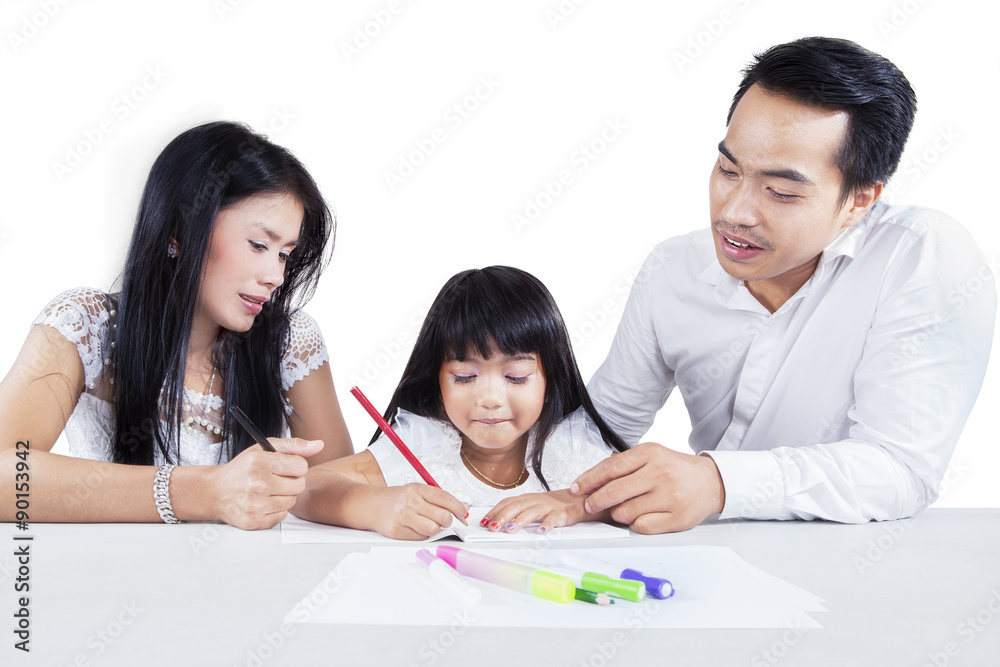 Hispanic parents help their daughter studying Hispanic parents help their daughter studying