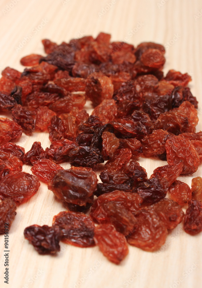 Brown raisins on wooden table, healthy eating Brown raisins on wooden table, healthy eating