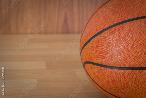 An official orange ball on a hardwood basketball court © tope007