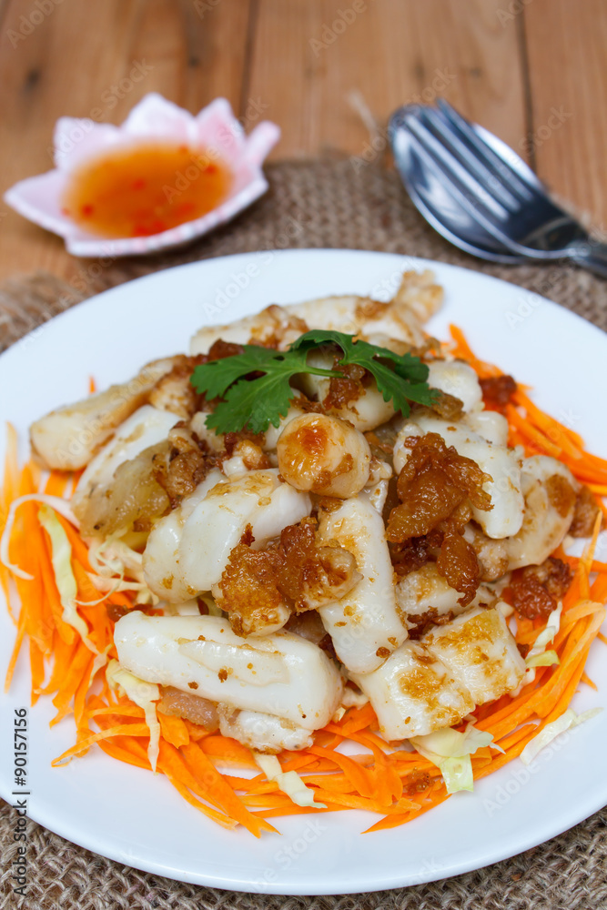 Fried squid serve with vegetable and sauce.
