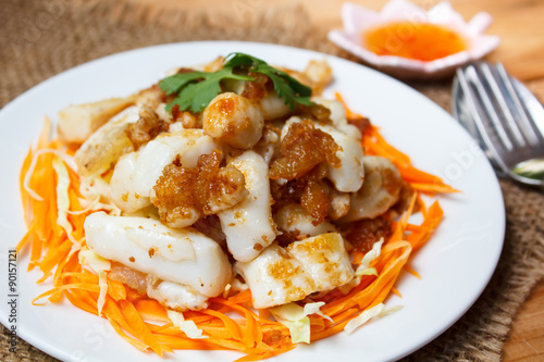 Fried squid serve with vegetable and sauce.