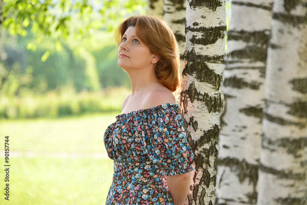 woman in a dress with open shoulders is about Birch woman in a dress with open shoulders is about Birch