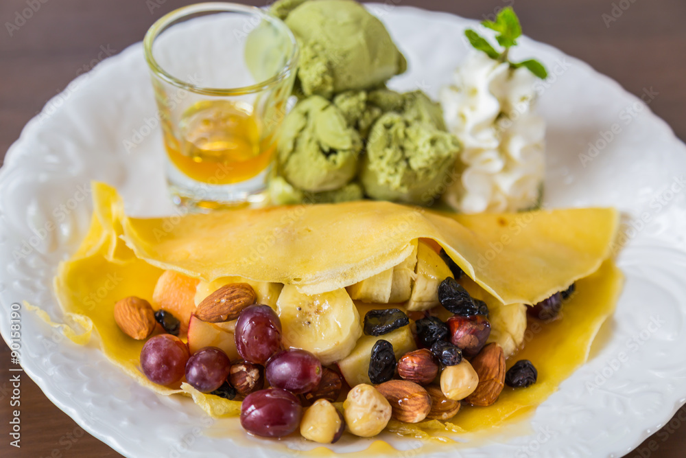 Pancake and fruit with ice cream on table