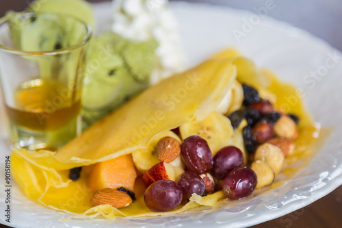 Pancake and fruit with ice cream on table