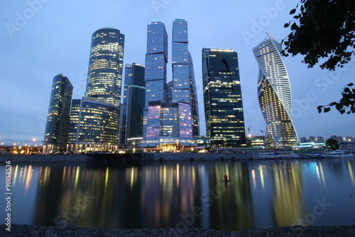 a modern business center in the evening and its reflection in the river
