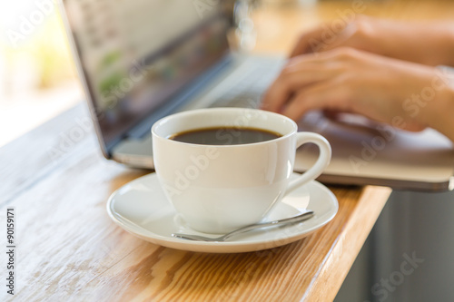Coffee cup with laptop on old wooden table