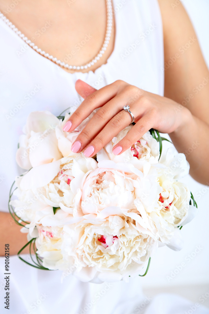 Bride holding wedding bouquet of white peonies, close-up Bride holding wedding bouquet of white peonies, close-up