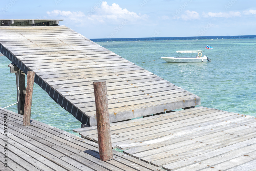 Boat and wooden platform facing to ocean.
