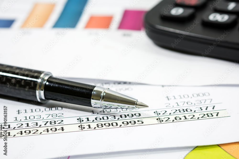 Black pen with financial report and calculator Black pen with financial report and calculator
