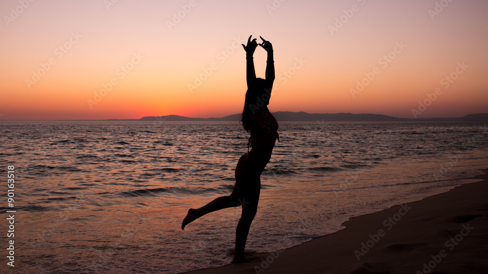 Woman practicing Yoga, sunset in the beach