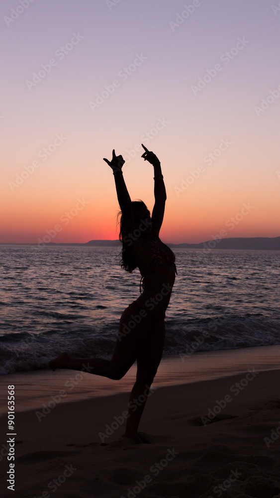 Woman practicing Yoga, sunset in the beach