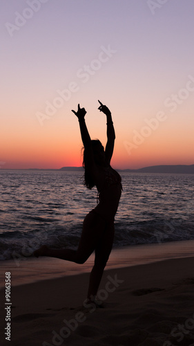 Woman practicing Yoga  sunset in the beach
