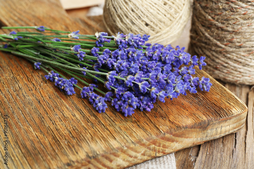 Fresh lavender and rope on wooden cutting board, closeup