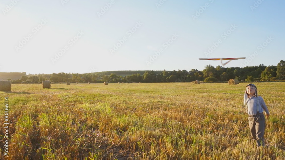 Happy Child Playing with an airplane on a meadow Happy Child Playing with an airplane on a meadow