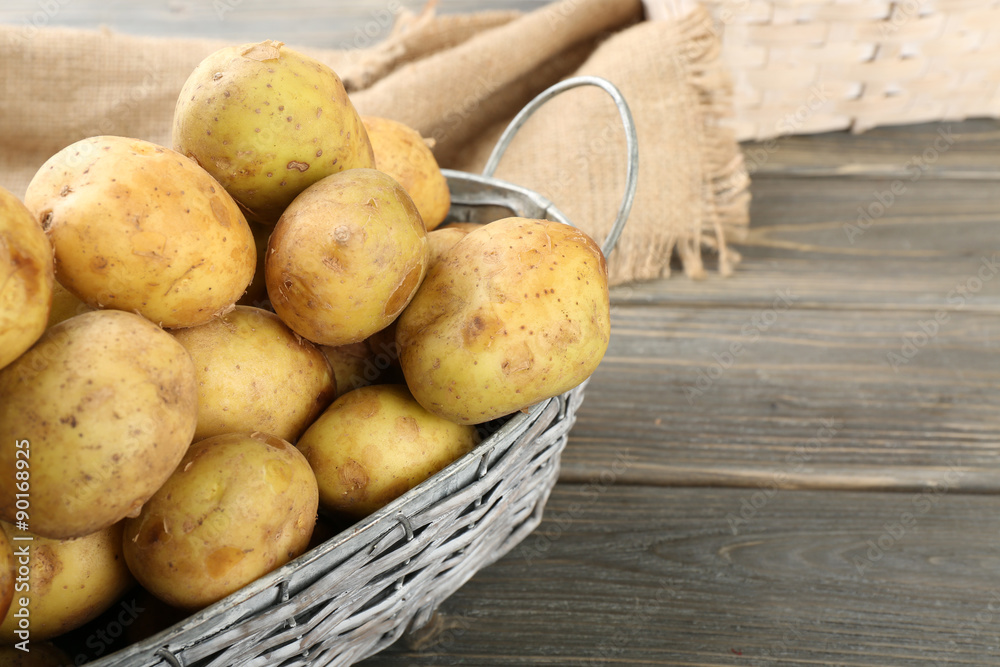 Young potatoes in wicker basket on wooden table close up Young potatoes in wicker basket on wooden table close up