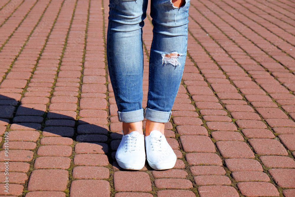 Female feet on paving stone background