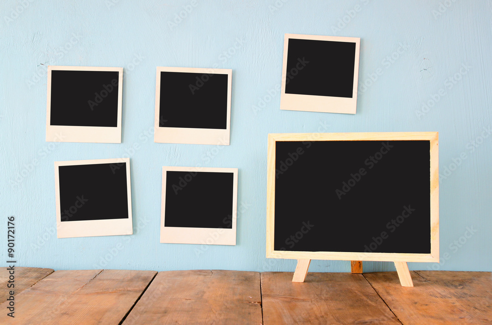 blank instant photos hang over wooden textured background next to blank blackboard
blank instant photos hang over wooden textured background next to blank blackboard