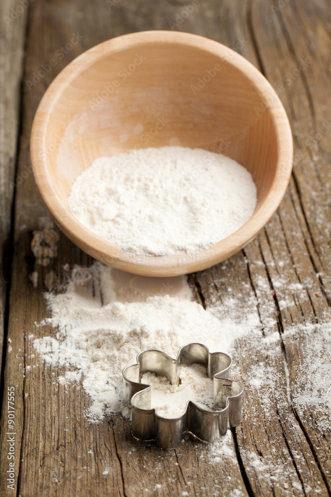 Wooden bowl with flour and cookie cutter Wooden bowl with flour and cookie cutter