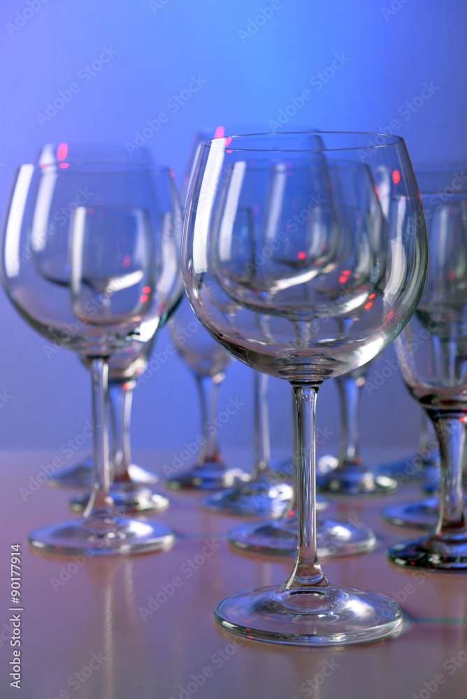 Empty wine glasses on color background