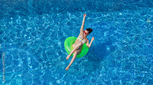 happy young sexy woman on swimming circle in swimming pool
