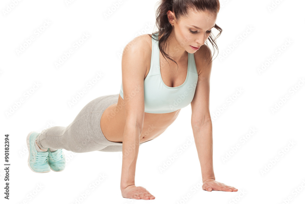 athletic woman doing push-ups on a white background. Fitness model with a beautiful, athletic body athletic woman doing push-ups on a white background. Fitness model with a beautiful, athletic body