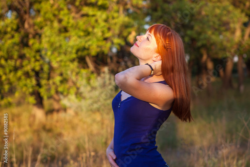 Beautiful red-haired girl posing in the outdoors