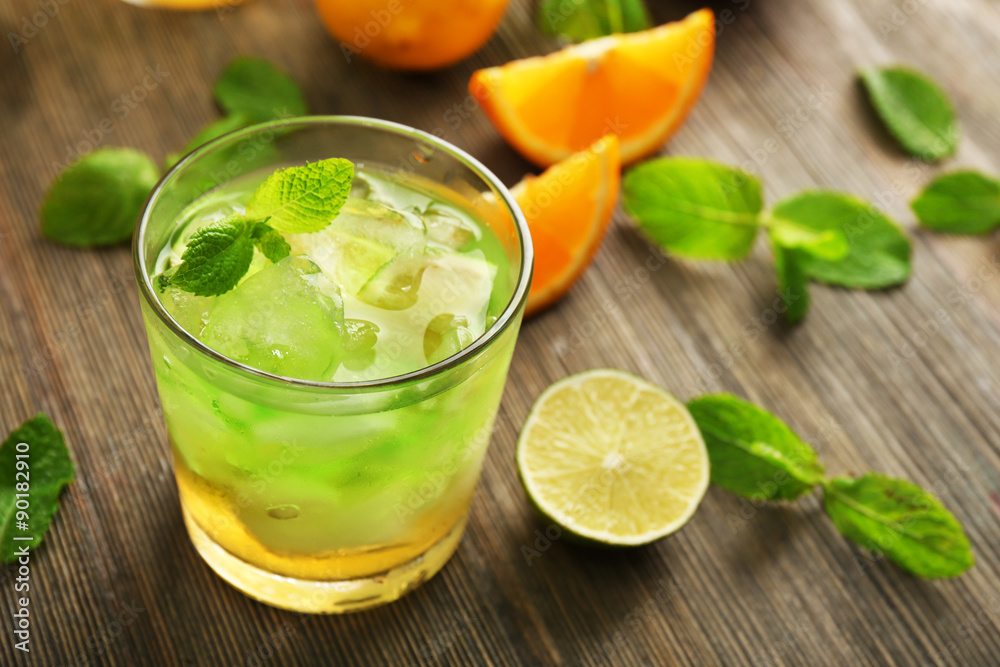 Glass of lime juice with orange on wooden background Glass of lime juice with orange on wooden background