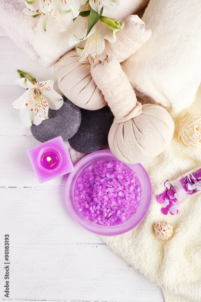 Massage bags with spa treatment and flowers on wooden table background Massage bags with spa treatment and flowers on wooden table background