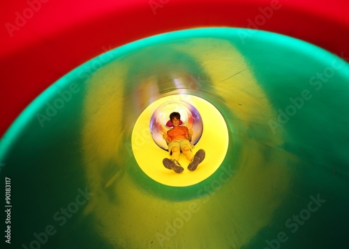 child slides in multicolored tunnel slide © ChiccoDodiFC
