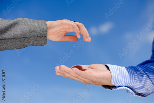 Hand giving and hand receiving on blue sky outdoors background