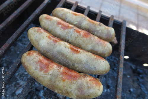 Pork - beef sausages on grill in the summer garden