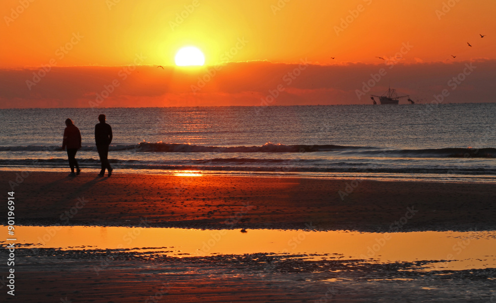 Couple on Ocean Beach at Sunrise