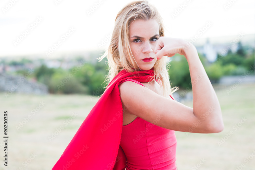 Young blonde woman looking at camera and show biceps.