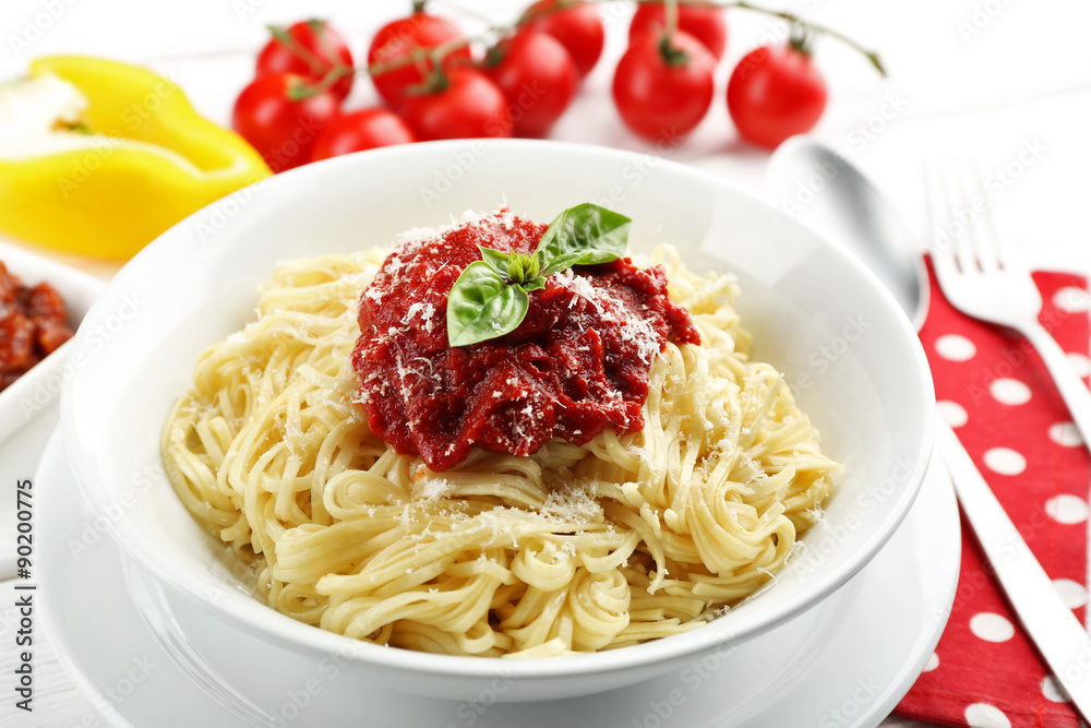Spaghetti with tomato sauce and cheese on white plate, on color wooden background Spaghetti with tomato sauce and cheese on white plate, on color wooden background
