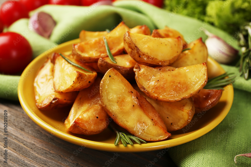 Baked potato wedges on wooden table, closeup Baked potato wedges on wooden table, closeup
