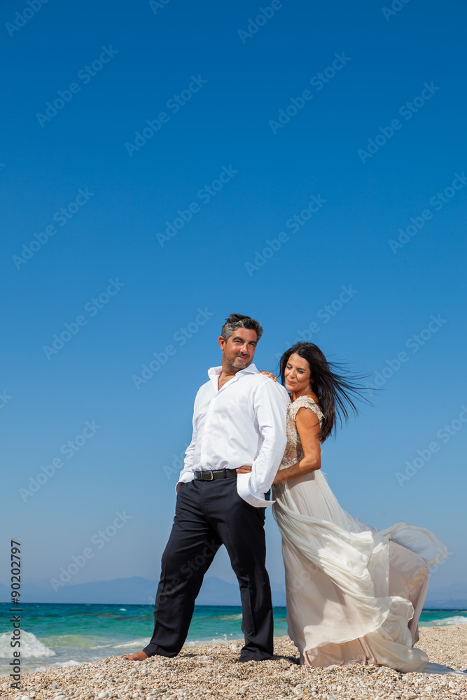 bride and groom, together in sunshine on a beautiful tropical be bride and groom, together in sunshine on a beautiful tropical be
