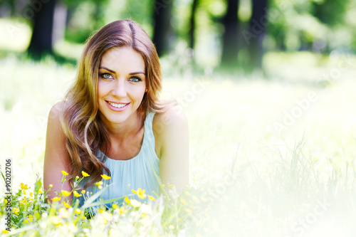 young woman in blue dress lying on grass