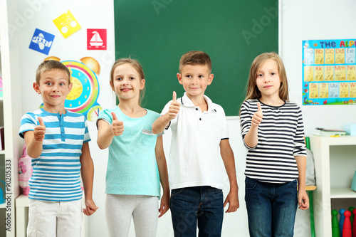 Portrait of happy classmates looking at camera in classroom