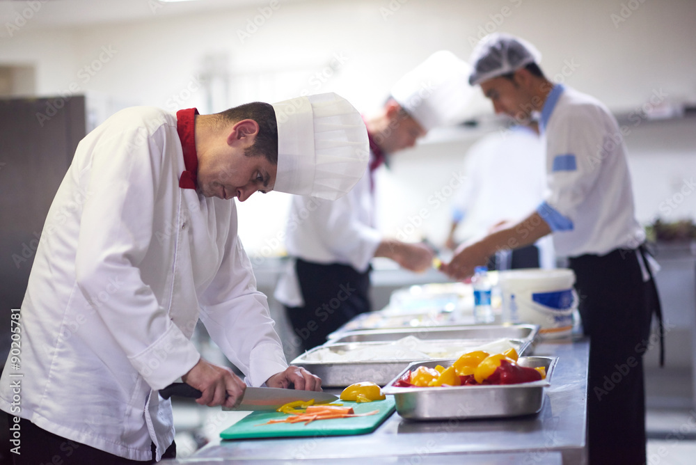 chef in hotel kitchen  slice  vegetables with knife