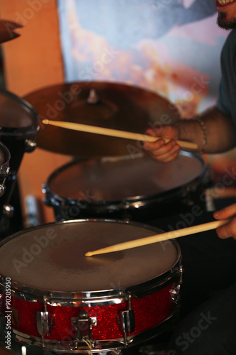 Drummer with wooden sticks and drums on dark background
