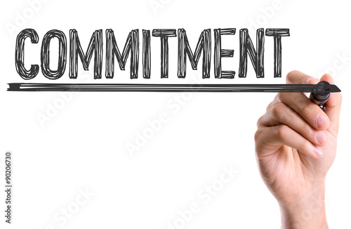 Hand with marker writing the word Commitment