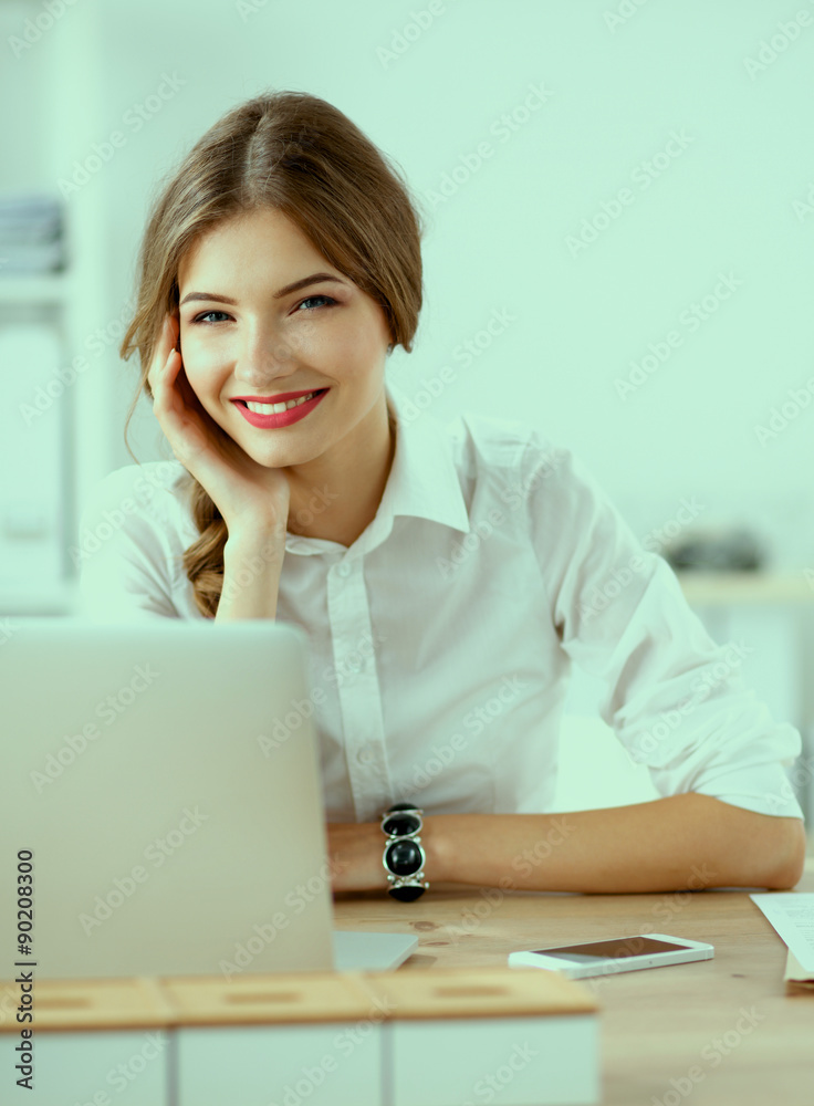 Attractive businesswoman sitting on desk in the office Attractive businesswoman sitting on desk in the office