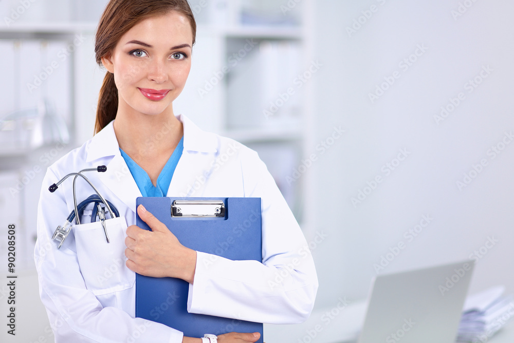 Smiling female doctor with a folder in uniform standing at Smiling female doctor with a folder in uniform standing at