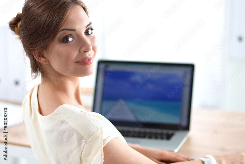 Portrait of a businesswoman sitting at desk with laptop Portrait of a businesswoman sitting at desk with laptop