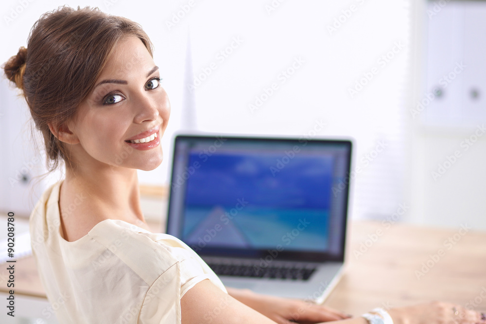 Portrait of a businesswoman sitting at desk with laptop Portrait of a businesswoman sitting at desk with laptop