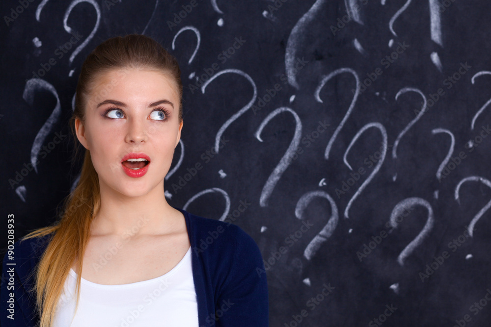 Young girl with question mark on a gray background Young girl with question mark on a gray background