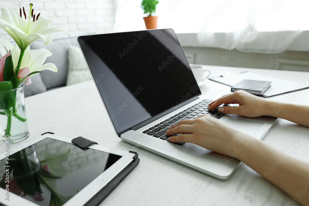 Fototapeta premium Woman using laptop at workplace in office
