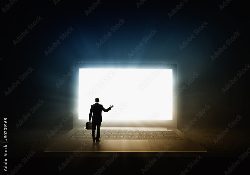 Obraz premium Man standing on big laptop